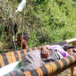 Petronela Nimut, warga Kampung Tadong, Desa Watu Umpu, Kecamatan Welak, ditandu menggunakan sarung dan bambu oleh warga menuju puskesmas untuk melahirkan pada Selasa (4/6/2024). Foto: Tajukflores.com